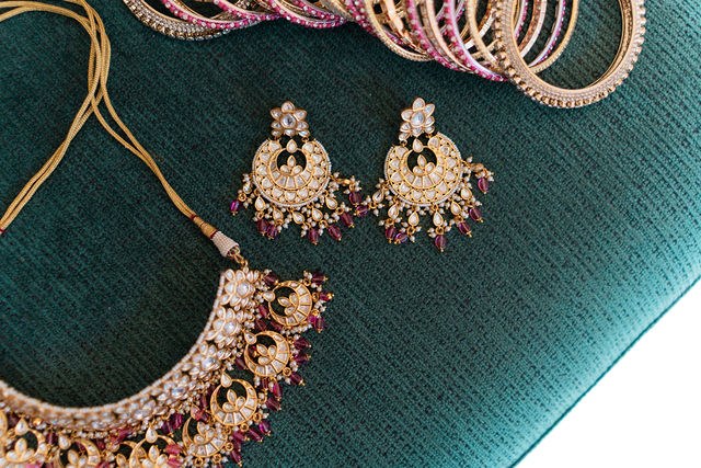 Anika’s wedding jewelry arranged on deep green fabric