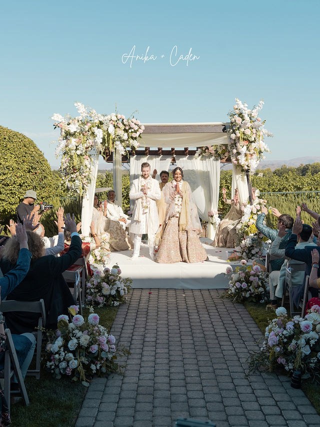 Anika and Caden at the flower-framed wedding mandap