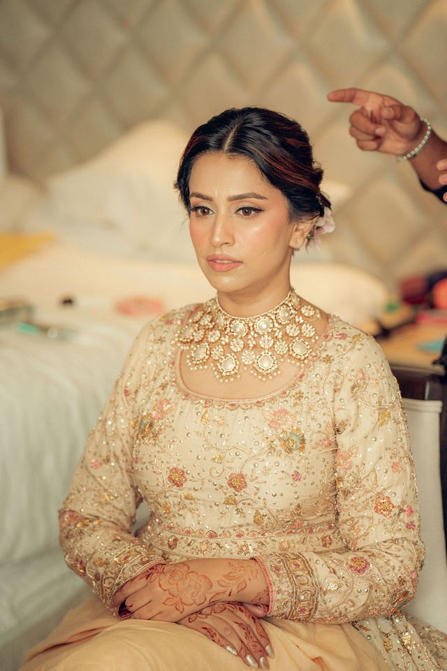 Aisha seated in her ivory embroidered bridal look