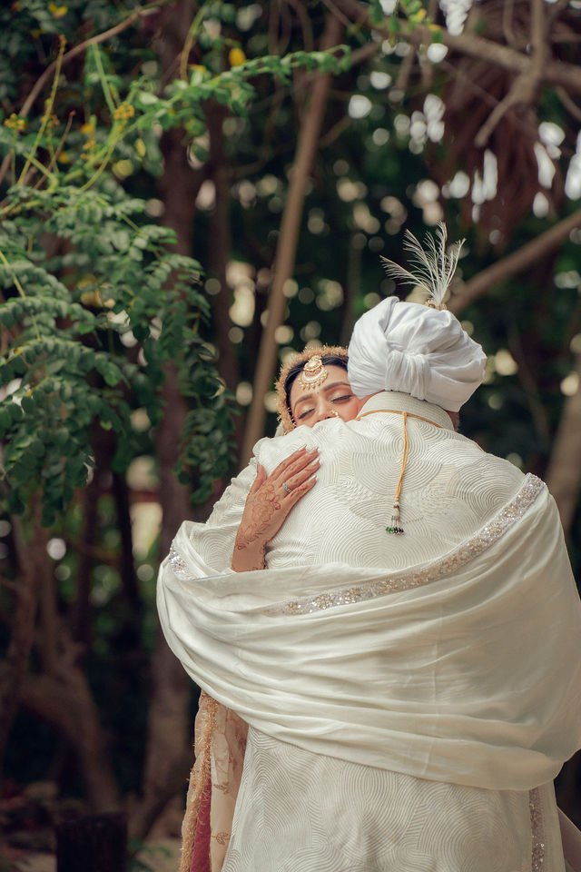 Aisha and Jiv embracing among the trees