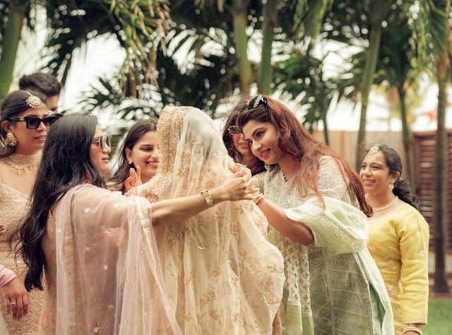 Aisha and friends sharing a tender moment under the palms