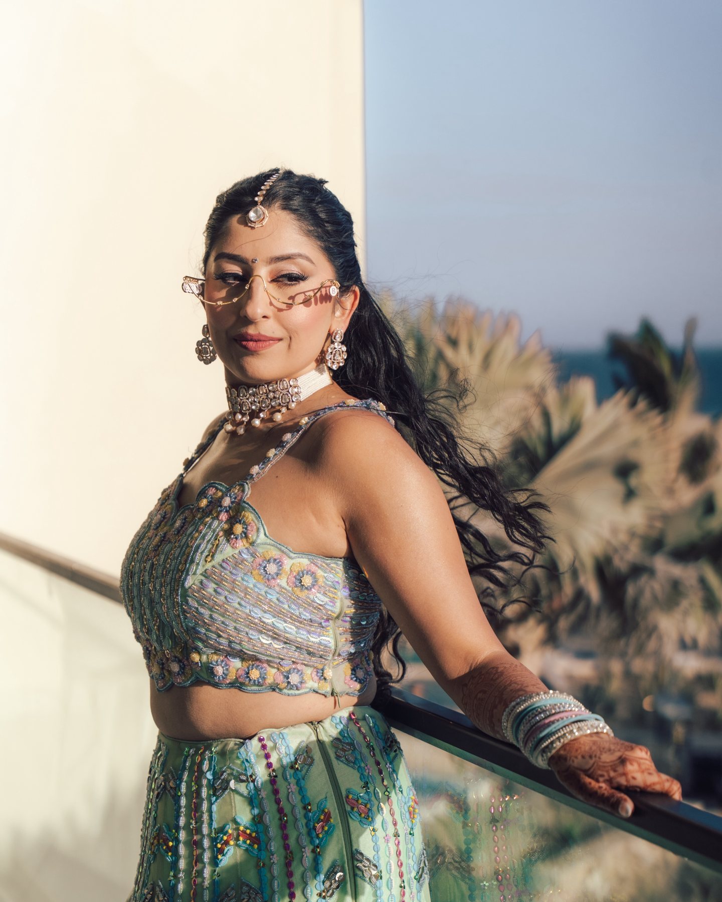 Alisha in mirrored eyewear and embroidered attire against the Cabo landscape