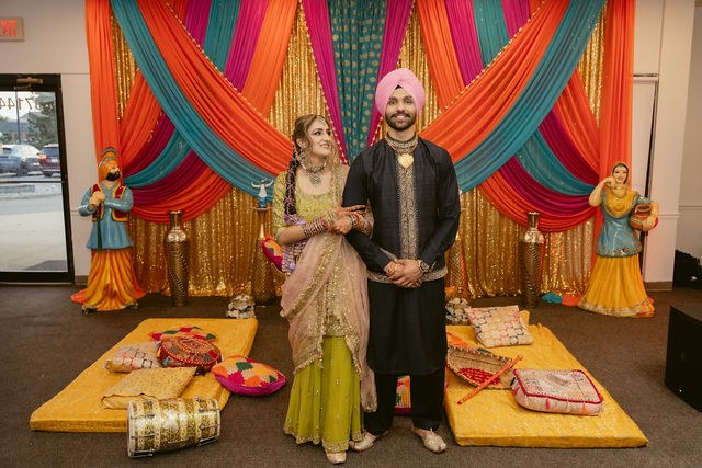 Banpreet and Yugraj together beneath the Jaggo drapery