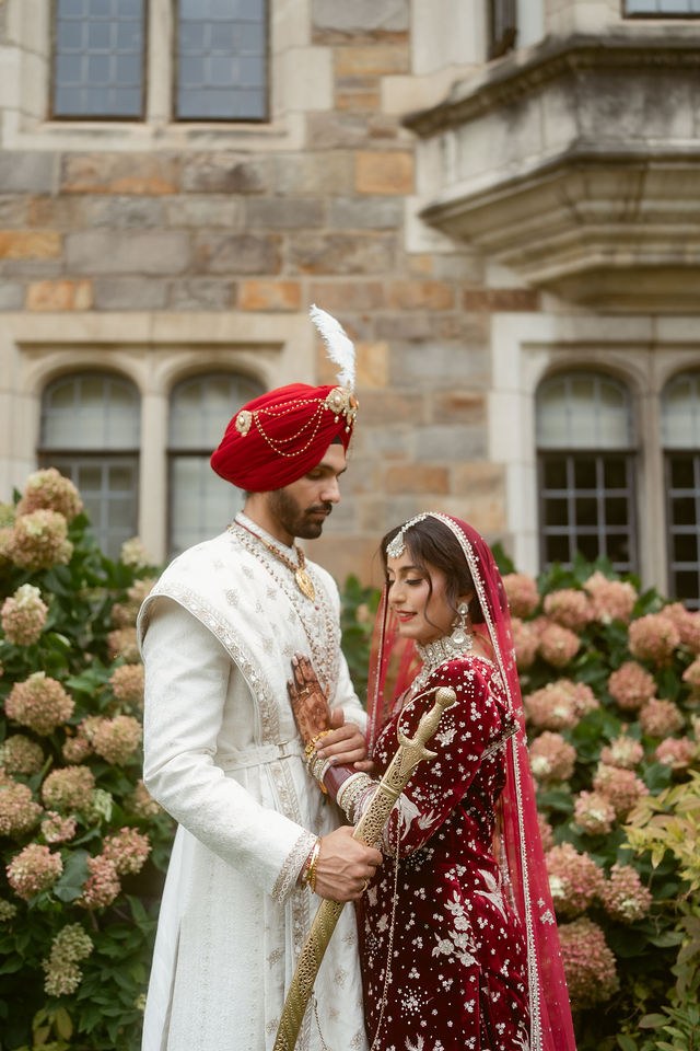 Banpreet and Yugraj together beneath flowering greenery