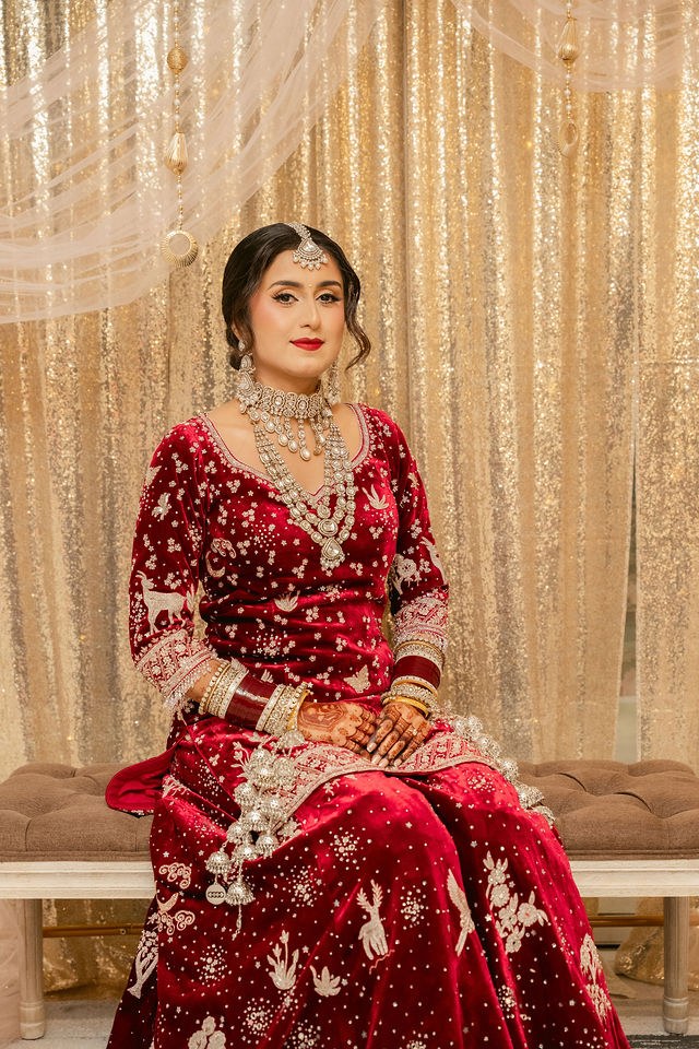 Banpreet seated in her deep red wedding outfit