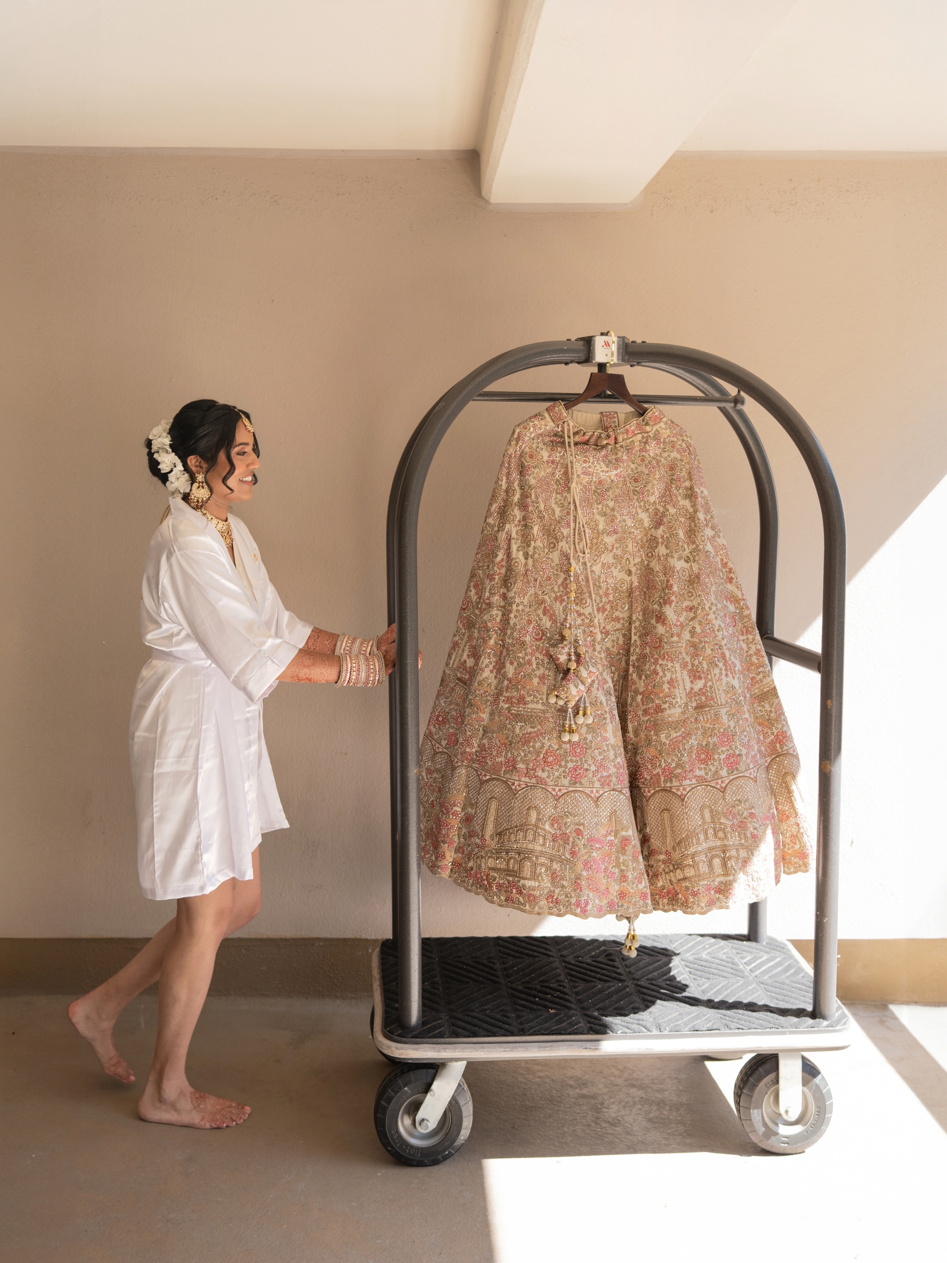 Anika beside her embroidered bridal outfit on the wedding morning