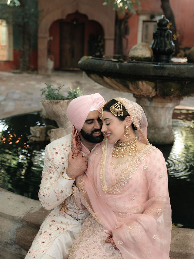 Jessey and Aman share a close portrait beside a fountain