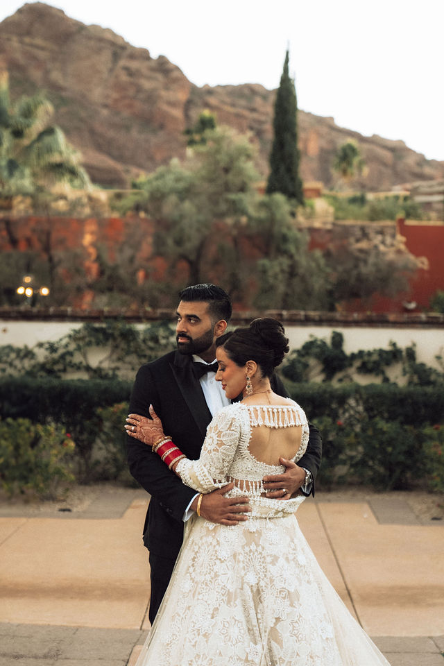 Jessey and Aman embrace with mountains in the distance
