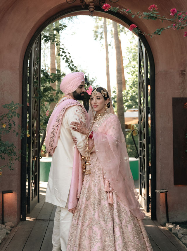 Jessey and Aman together beneath a warm stone archway