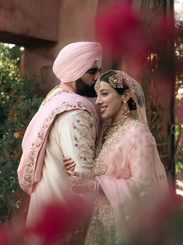 Jessey and Aman in a close wedding portrait framed by flowers