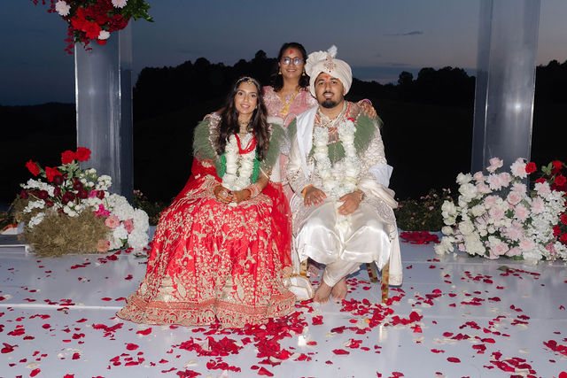 Khyati and Bishal beneath the floral ceremony arch at dusk