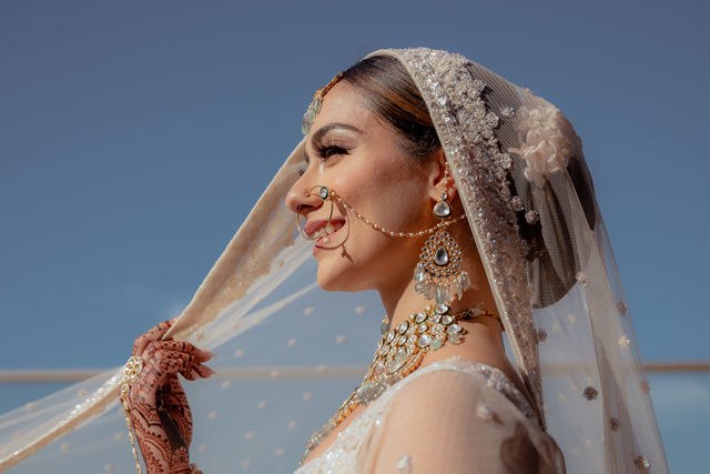 Grace smiling beneath her bridal veil in the Los Cabos sunlight
