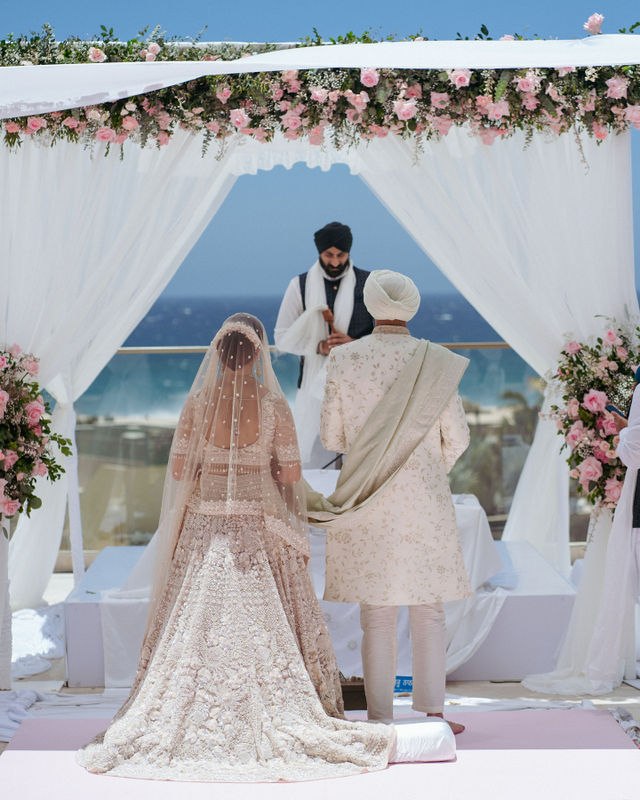 Grace and Karan walking together at the ceremony by the sea