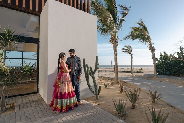 Grace and Karan standing together near the shore