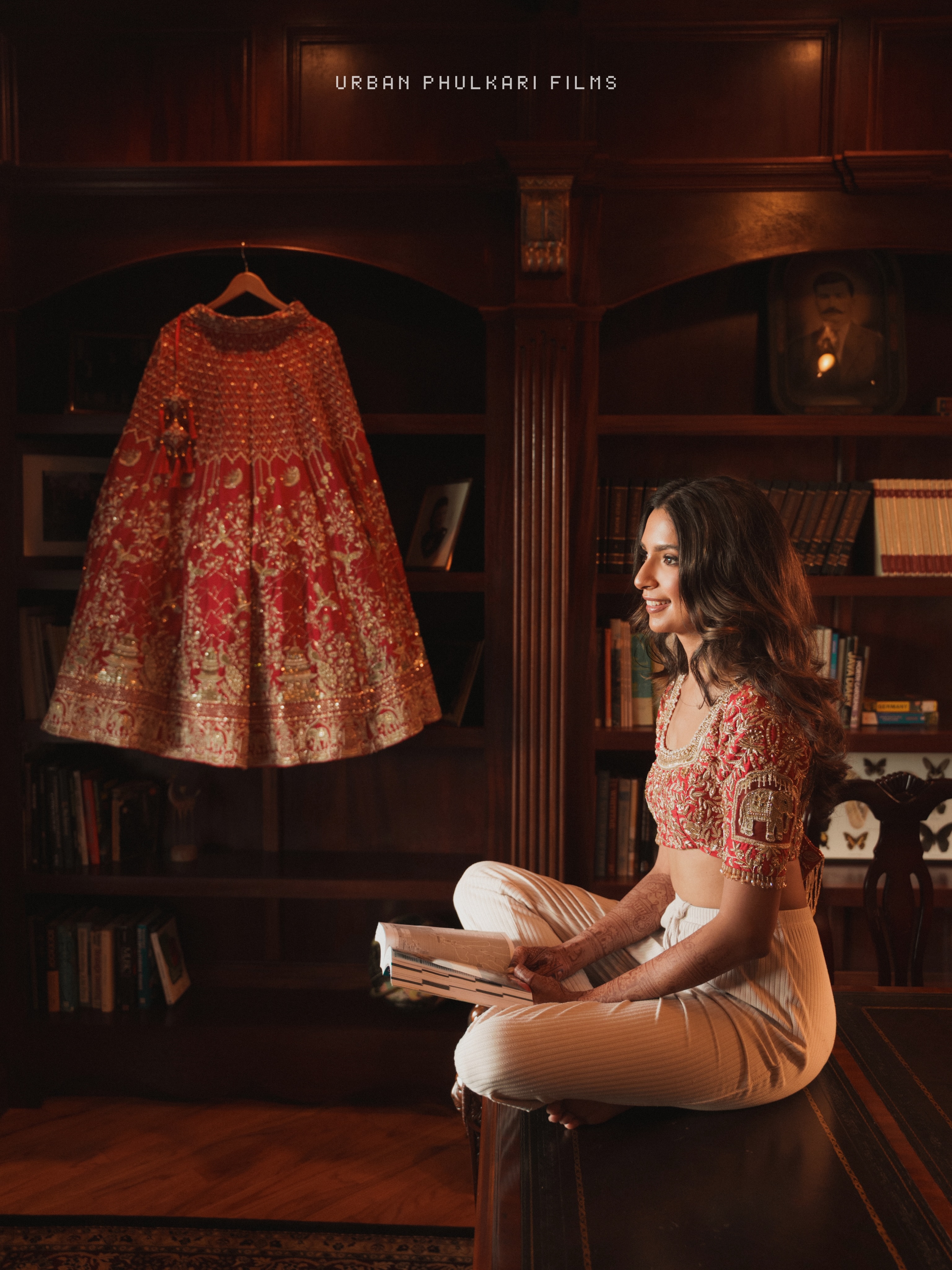 Khyati seated beside her red bridal outfit in her Instagram portrait