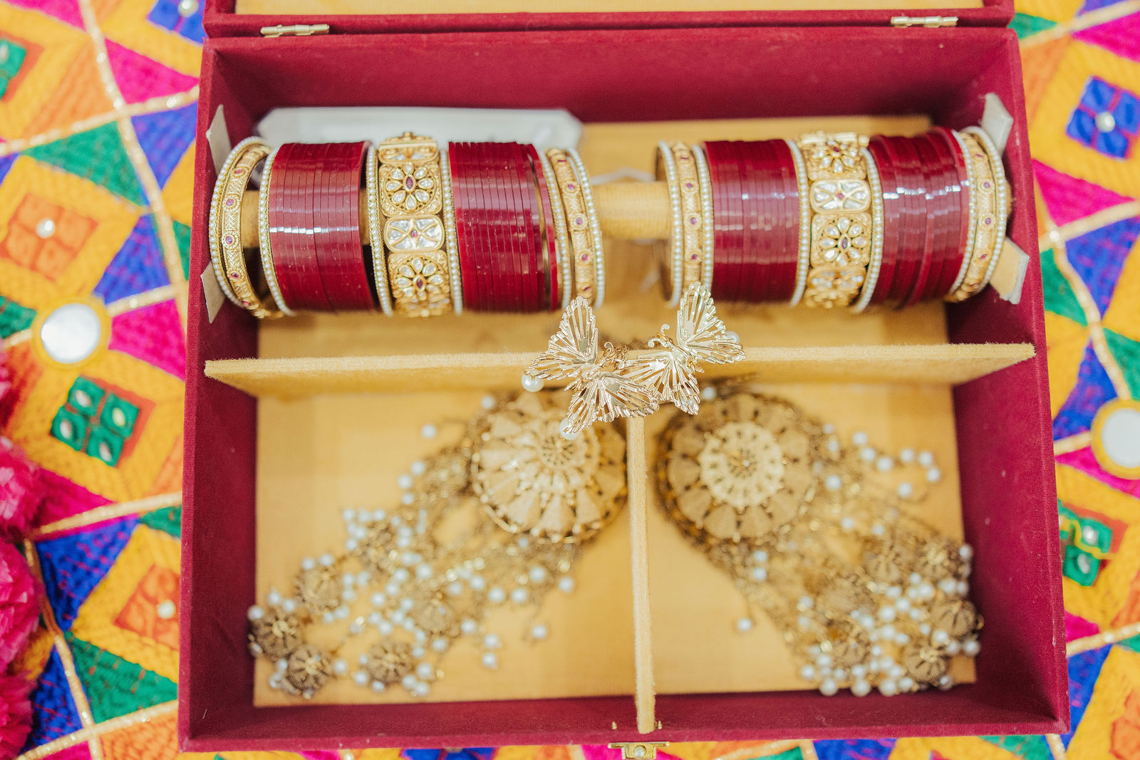 Red bridal bangles and gold jewelry in their presentation box