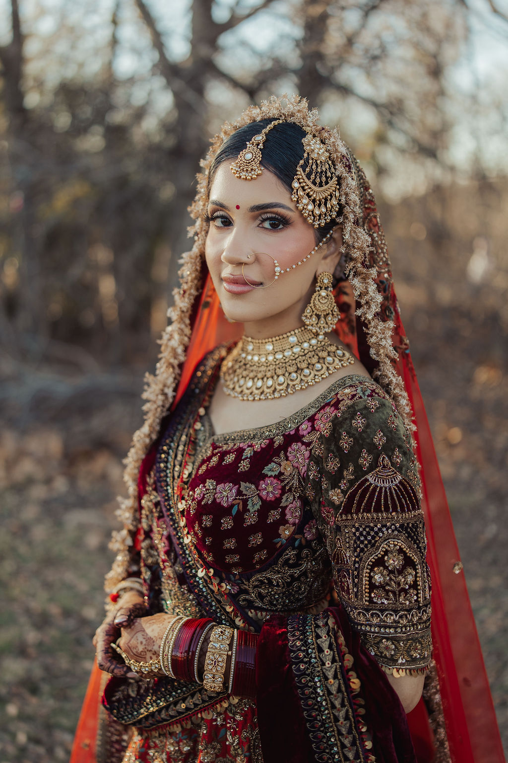 A bridal portrait in maroon and gold embroidery