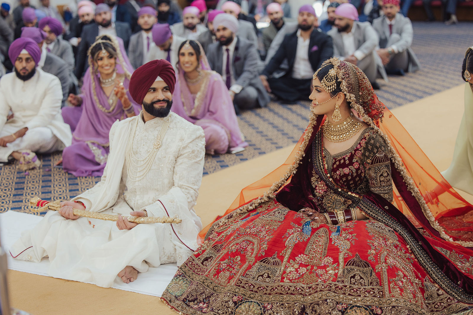The couple seated together at their Sikh wedding ceremony