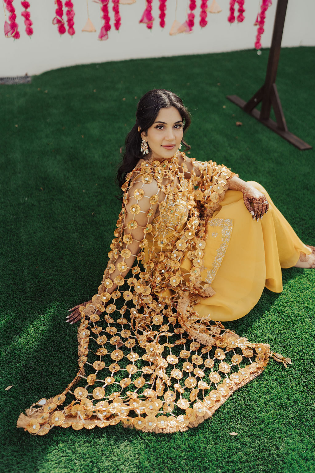 The bride seated in her yellow Haldi outfit