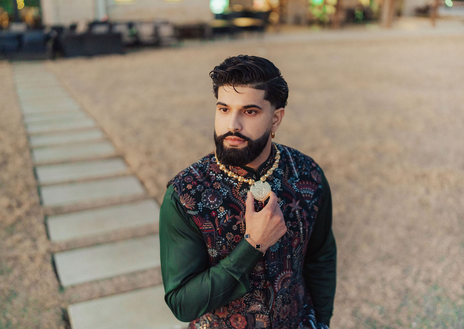 The groom in embroidered green attire before Jaggo