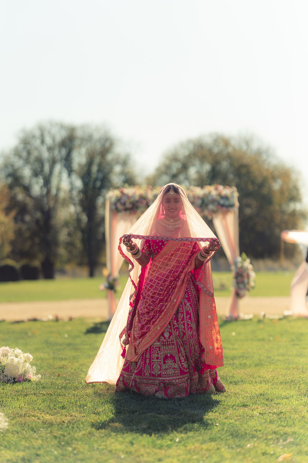 Monali in red bridal attire on the lawn