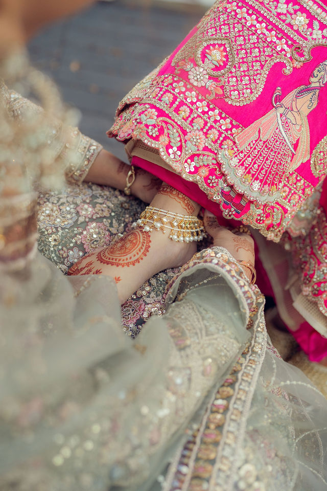 An intimate detail of hands and embroidered wedding attire