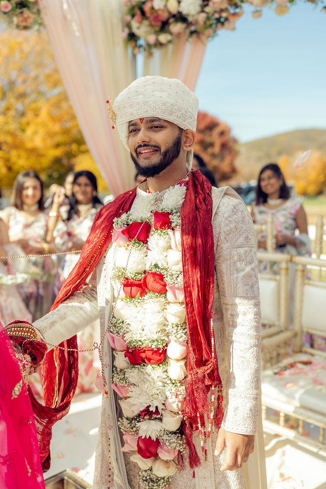 Sunny beneath the floral mandap wearing his wedding garlands