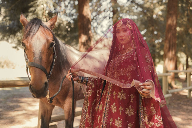 Naba in her red wedding attire beside a horse