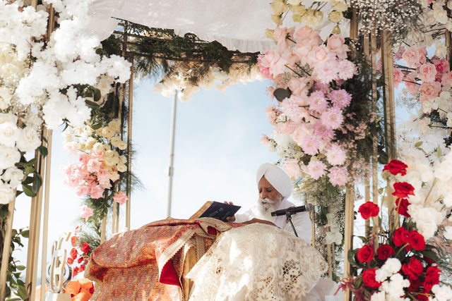 Paul and Gureet framed by ceremony flowers