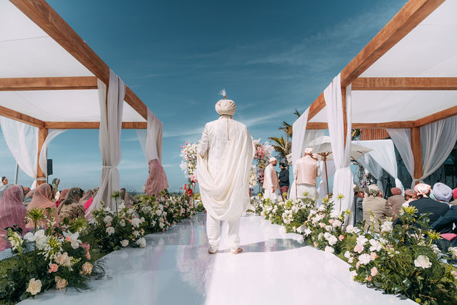A wide portrait of Paul beside the ceremony canopy