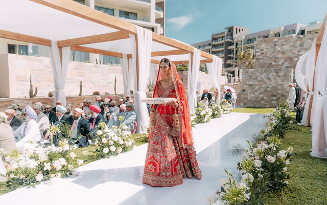 Gureet enters the ceremony in her red bridal attire