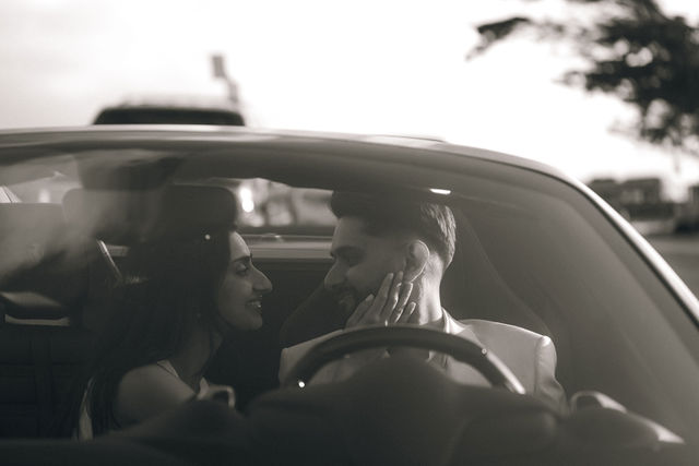 A cinematic black-and-white portrait of Paul and Gureet inside a car