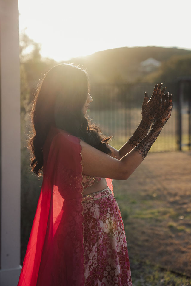 Rachana raising her hennaed hands in the warm afternoon light