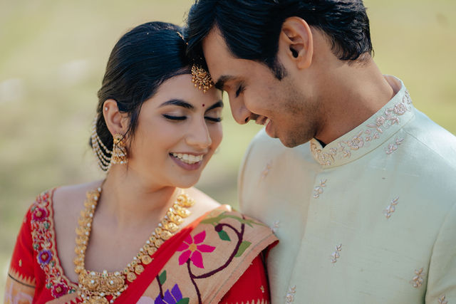 Rachana and Anoop in a close outdoor portrait before Pooja