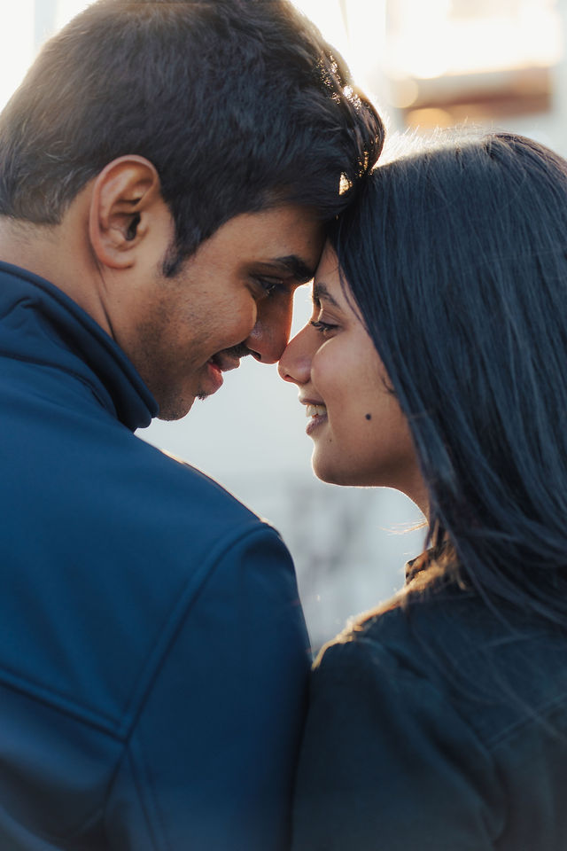 Rachana and Anoop leaning close in a warm pre-wedding portrait