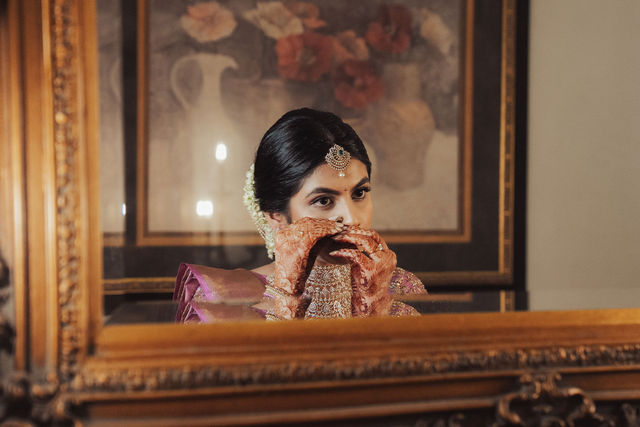 Rachana seen in a mirror while getting ready for the wedding
