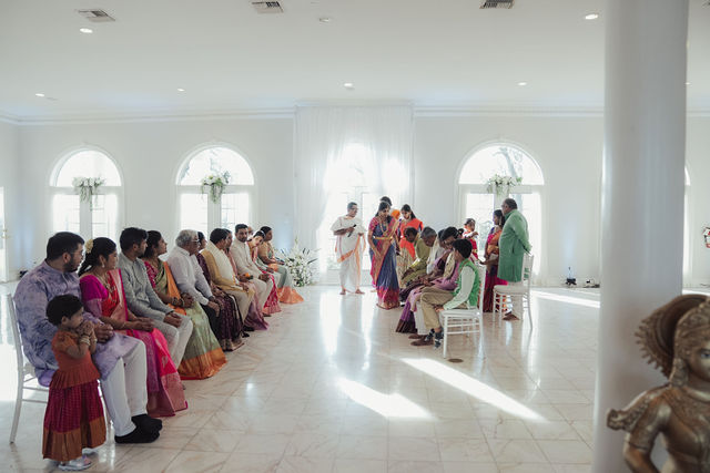 Family gathered in a light-filled room for a wedding-day ceremony