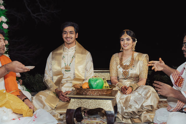Rachana and Anoop seated together beneath the floral mandap