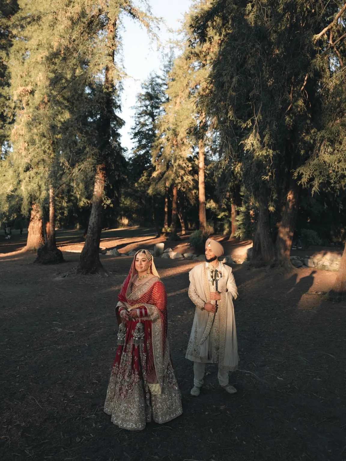 Wedding portraits among tall trees at Woodward Park in Fresno