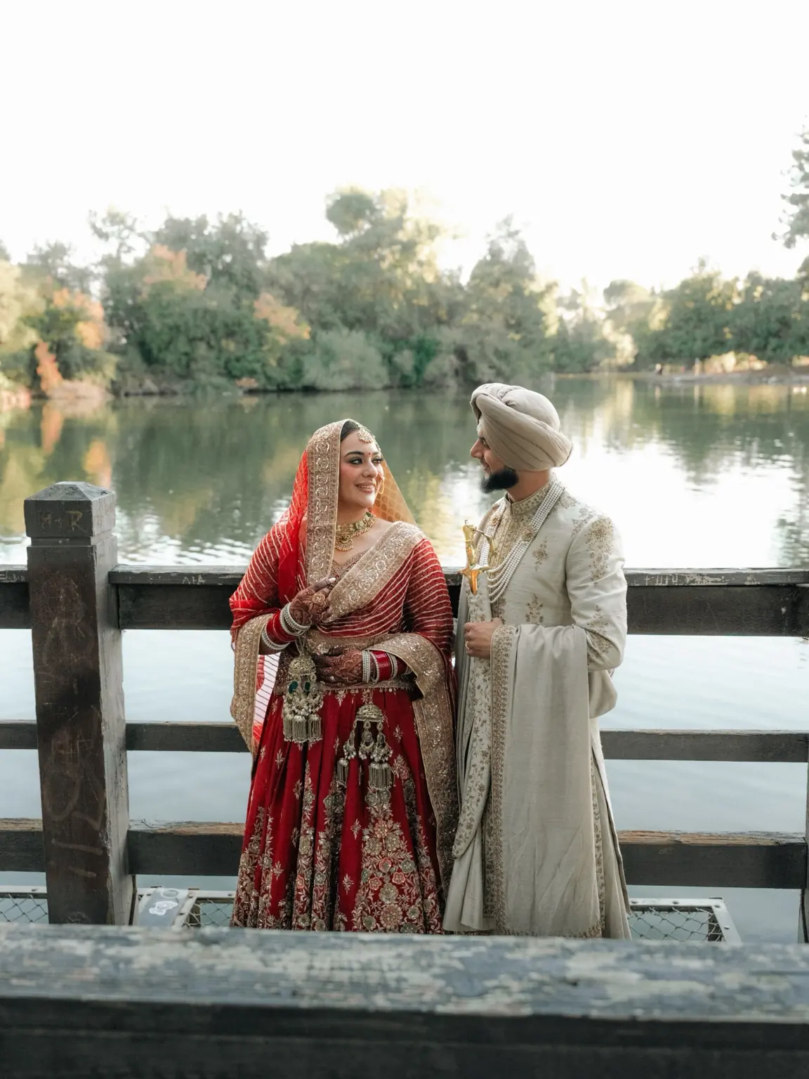 Ramandeep and Jaskaran smile at one another beside the water