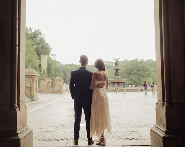 Richa and Shahil silhouetted in the opening of a stone arcade