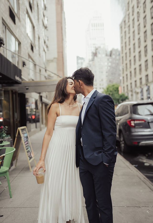 Richa and Shahil kissing on a city sidewalk