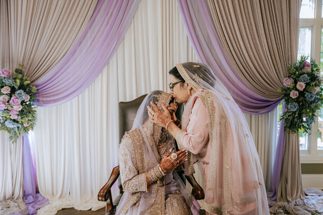Sakhi in her pastel bridal attire beside a family member