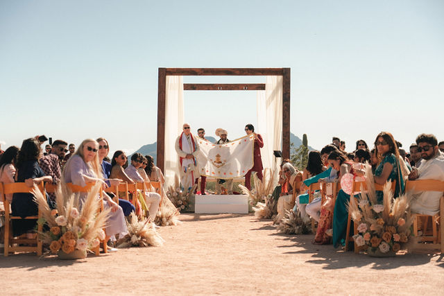 Shachi and Roni within the mandap surrounded by guests