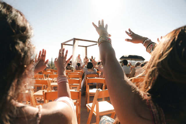 Guests raise their hands during the wedding celebration