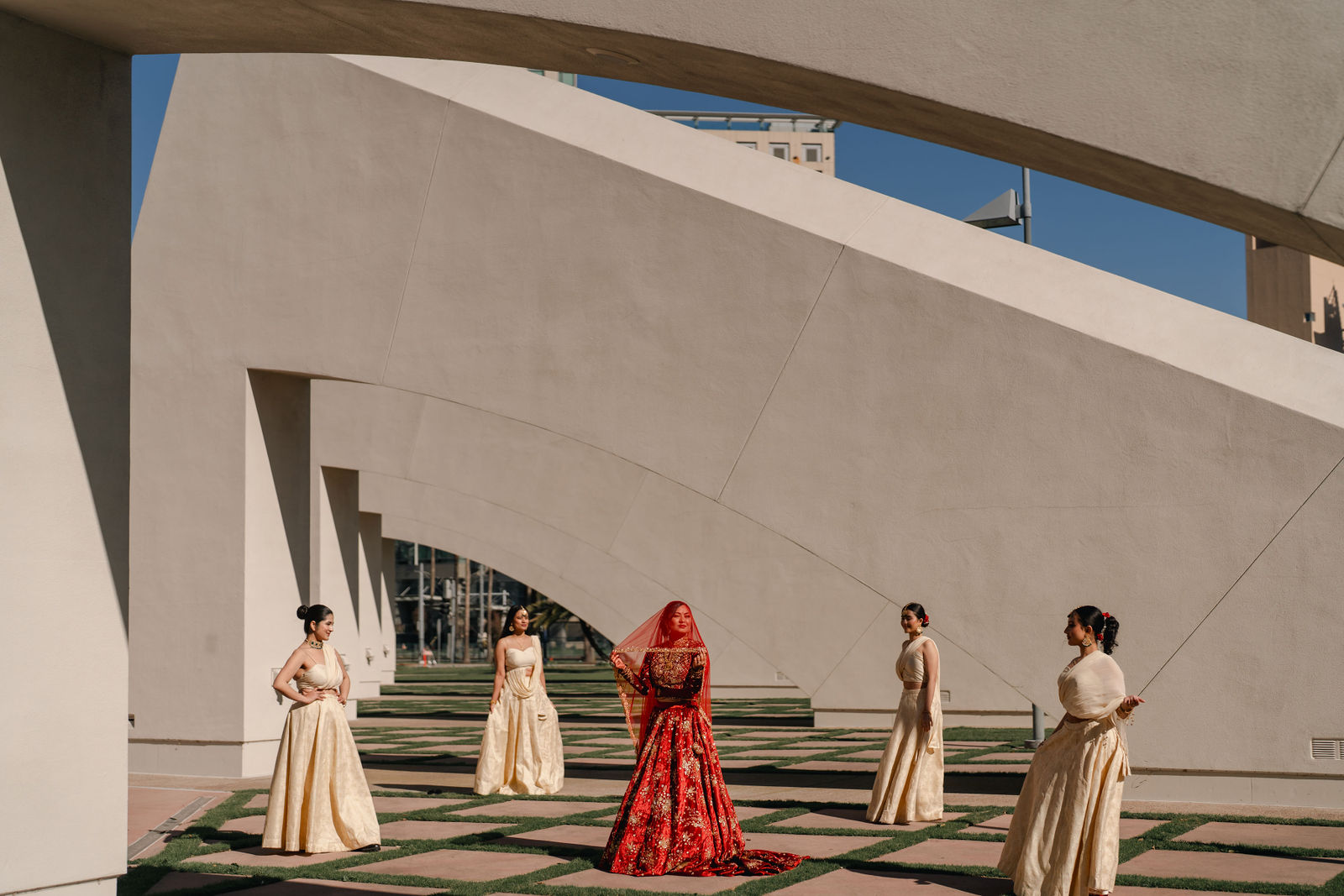 Shayal with her bridal party before sculptural architecture