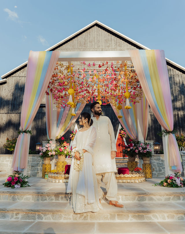 Shrusti and Rishi beneath the colorful outdoor canopy