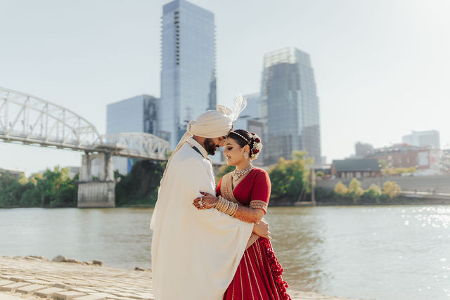 Shrusti and Rishi embracing beside the Nashville riverfront