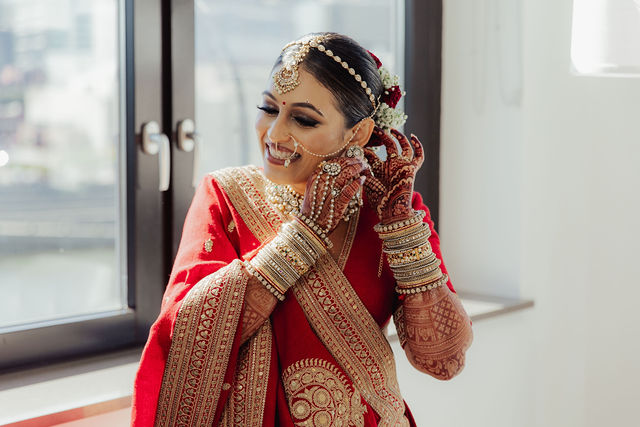 Shrusti finishing the details of her red bridal look