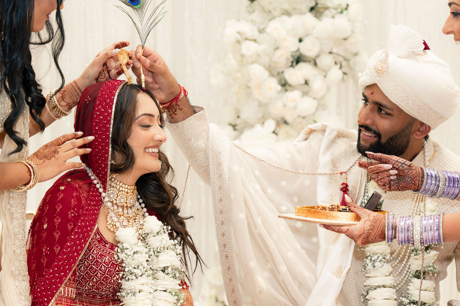 Sonalii and Ravin smiling during a family wedding ritual